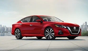 2023 Nissan Altima in red with city in background illustrating last year's 2022 model in Casa Nissan in El PASO TX